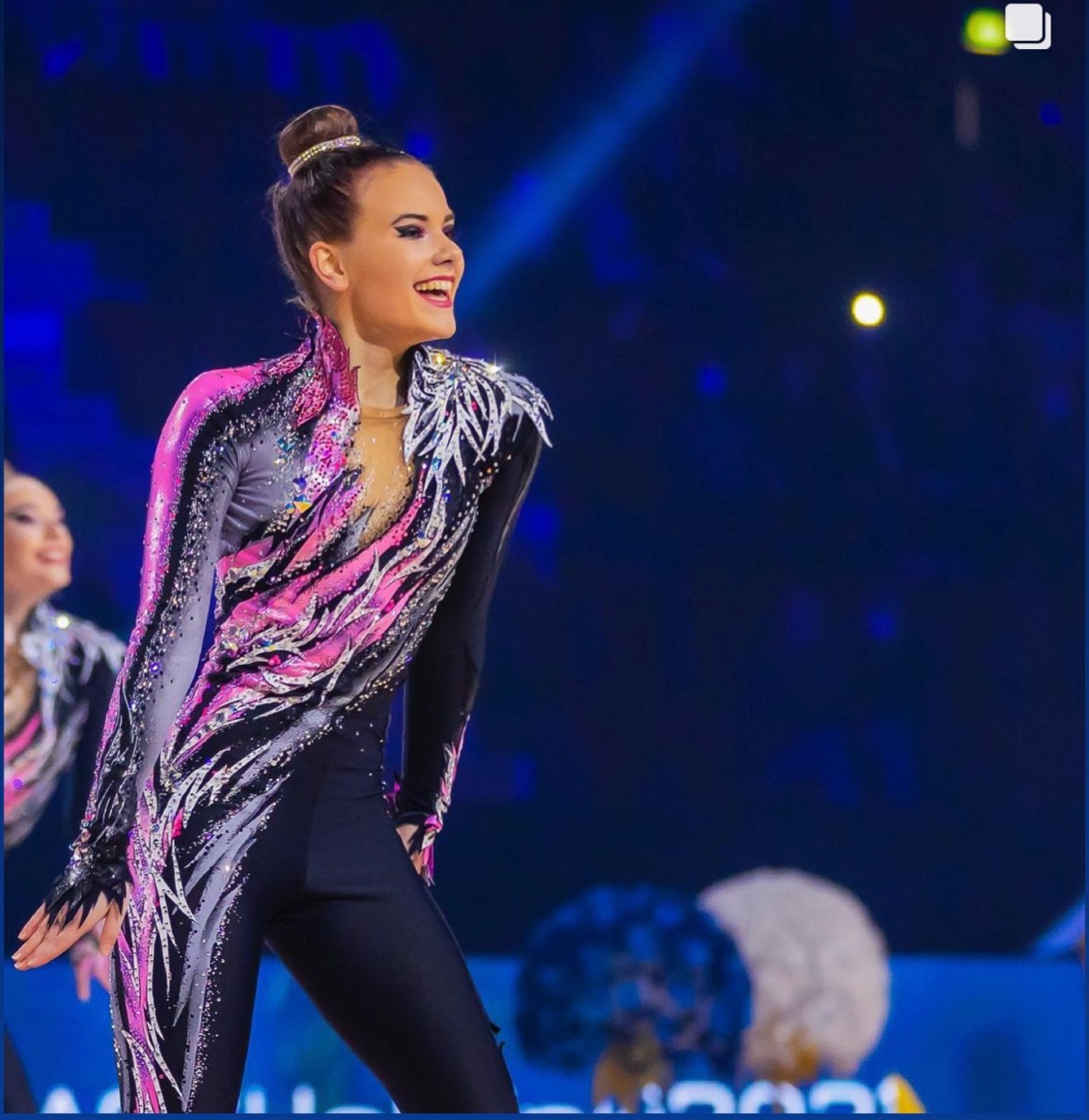 Gymnast in a black, pink and silver team unitard